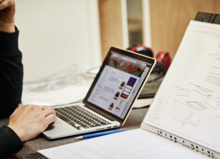Furniture designer with sketches and laptop