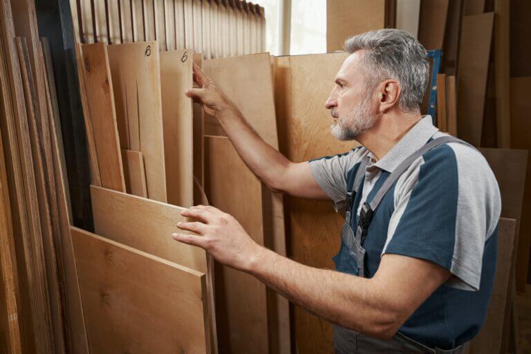 Close up of aged master looking at plywood sheets